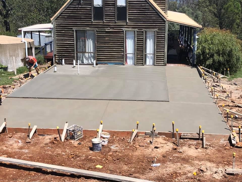 Newly Poured Concrete Patio Beside a Wooden House — Heritage Concrete In Uralla, NSW