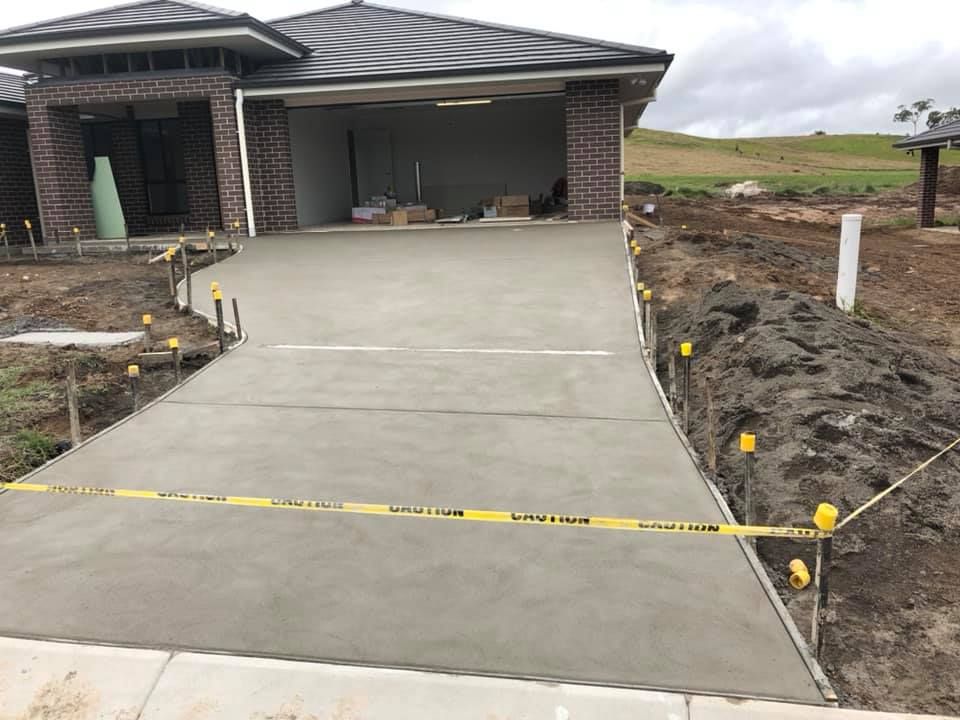 Freshly Poured Concrete Driveway Leading to a Garage Under Construction — Heritage Concrete In Uralla, NSW