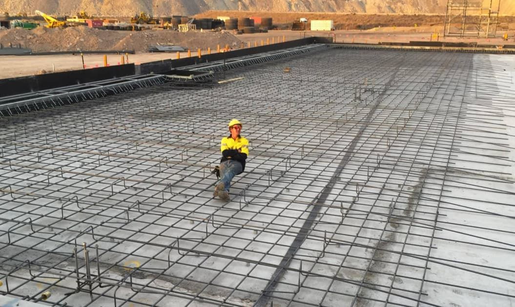 A Construction Worker Is Standing On A Concrete Floor — Heritage Concrete In Uralla, NSW