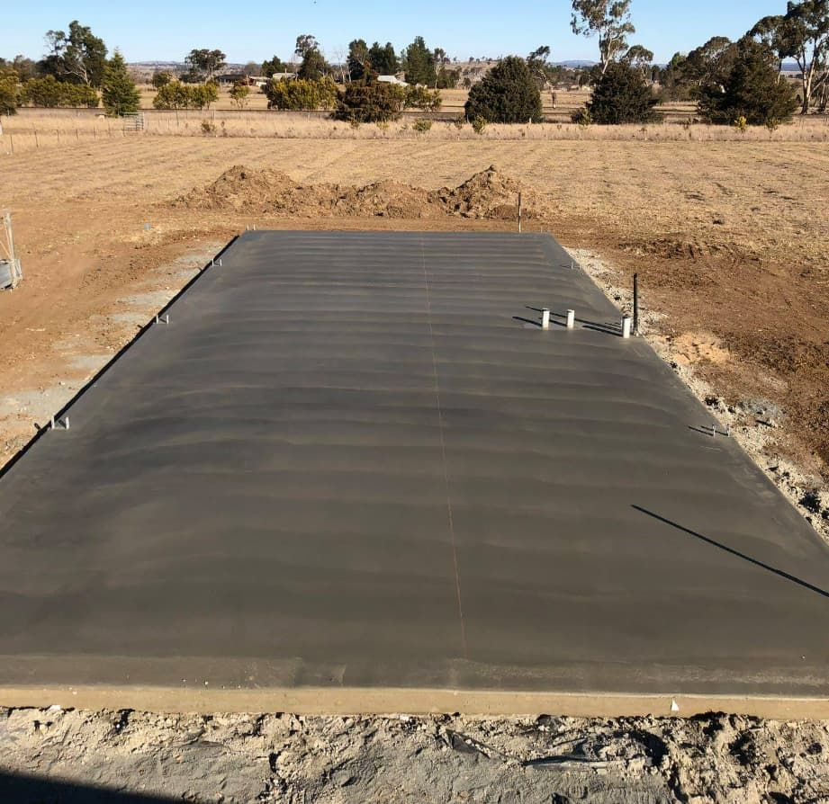 A Large Concrete Slab Is Sitting In The Middle Of A Dirt Field — Heritage Concrete In Uralla, NSW