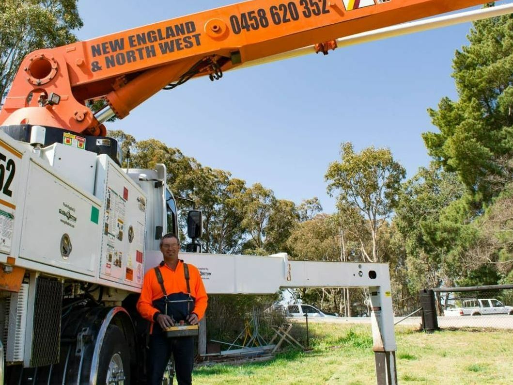 A Man Standing In Front Of A New England & North West Truck — Heritage Concrete In Uralla, NSW