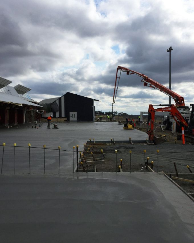 A Concrete Pump Is Being Used To Pour Concrete Into A Parking Lot — Heritage Concrete In Uralla, NSW