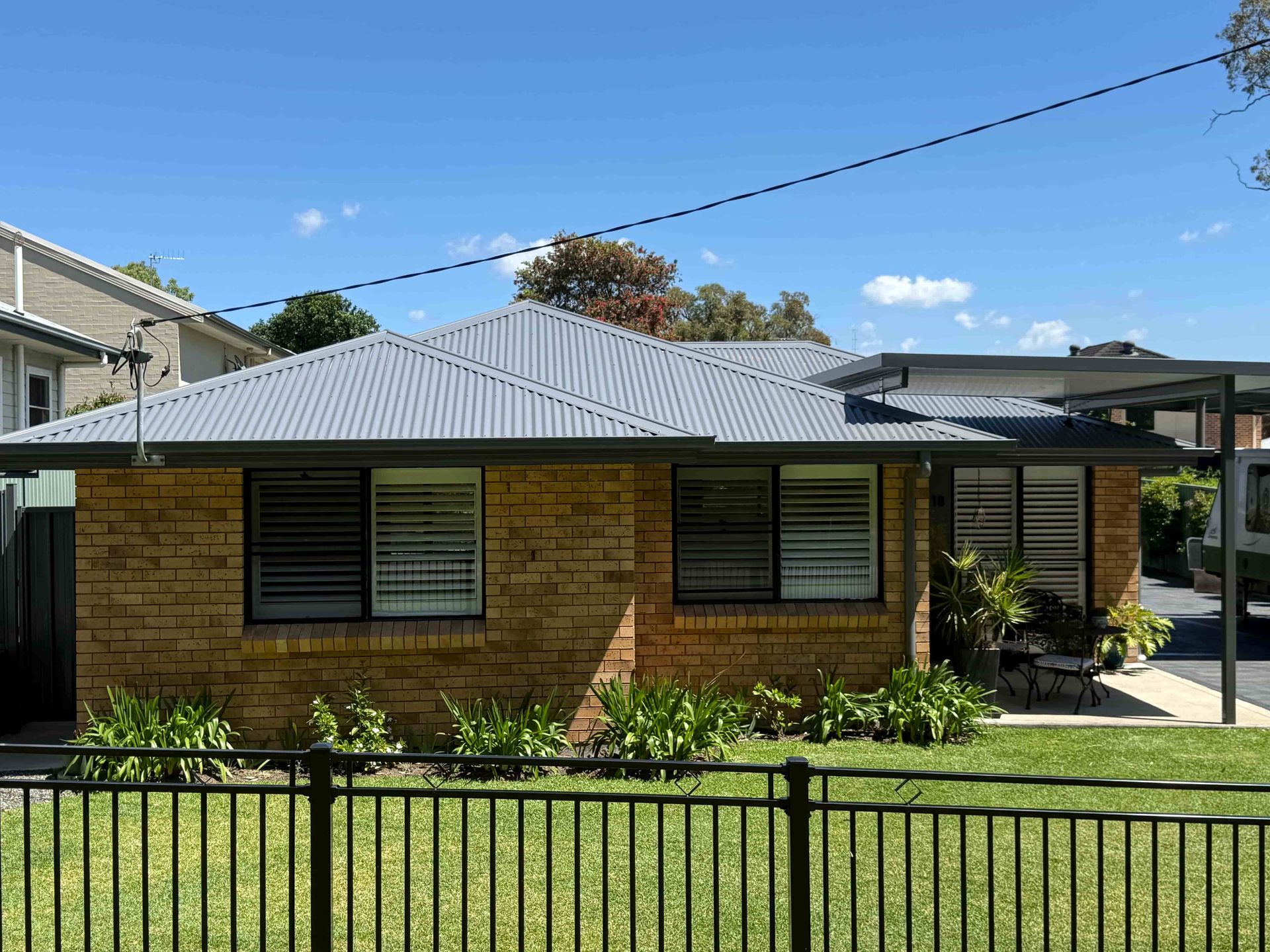 Dark Gray Metal Roof with Chimney and Skylight — Hi Tech Roofing in Cessnock, NSW