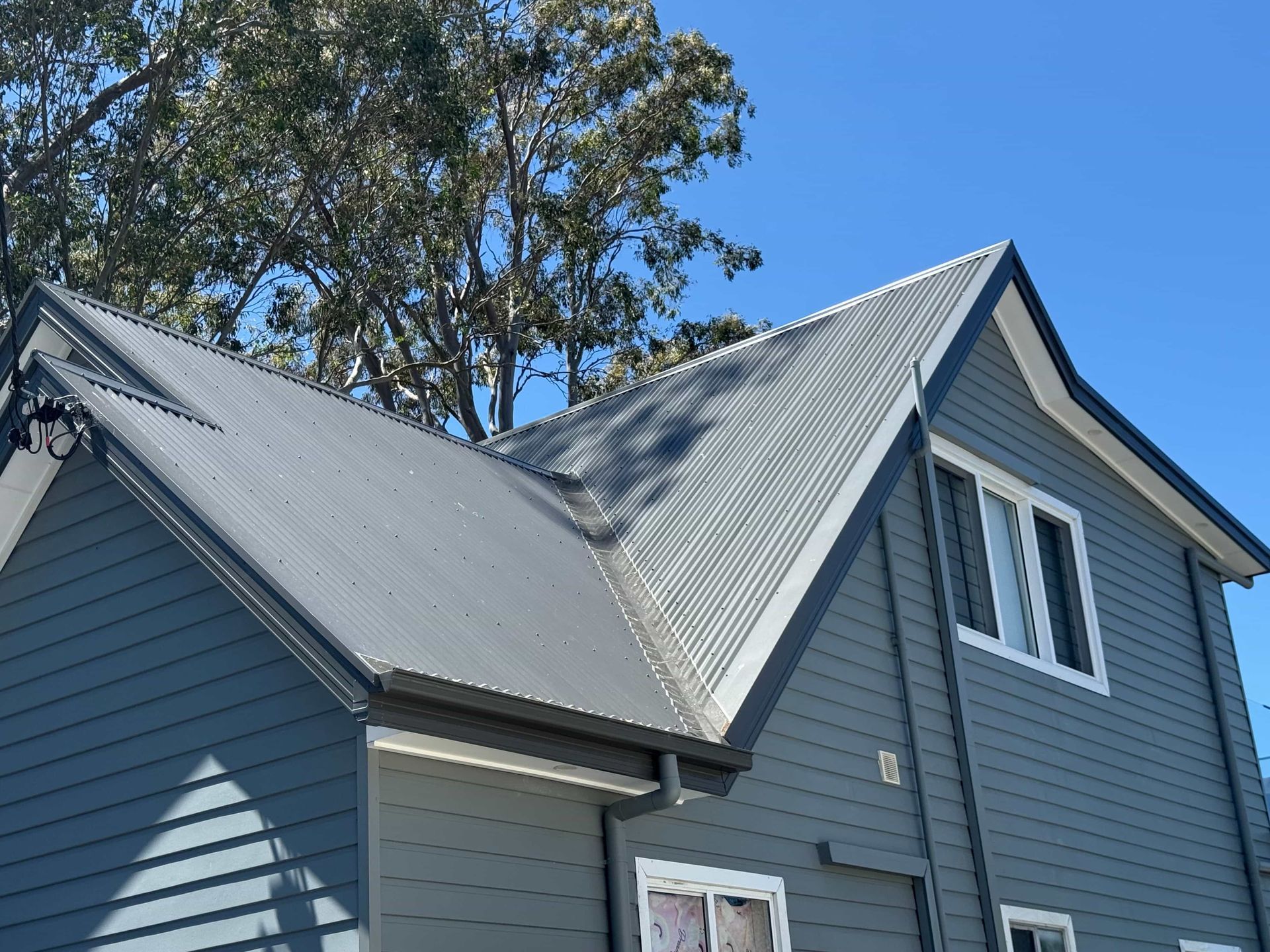 Gray corrugated metal roof on gray building — Hi Tech Roofing in Kilaben Bay, NSW