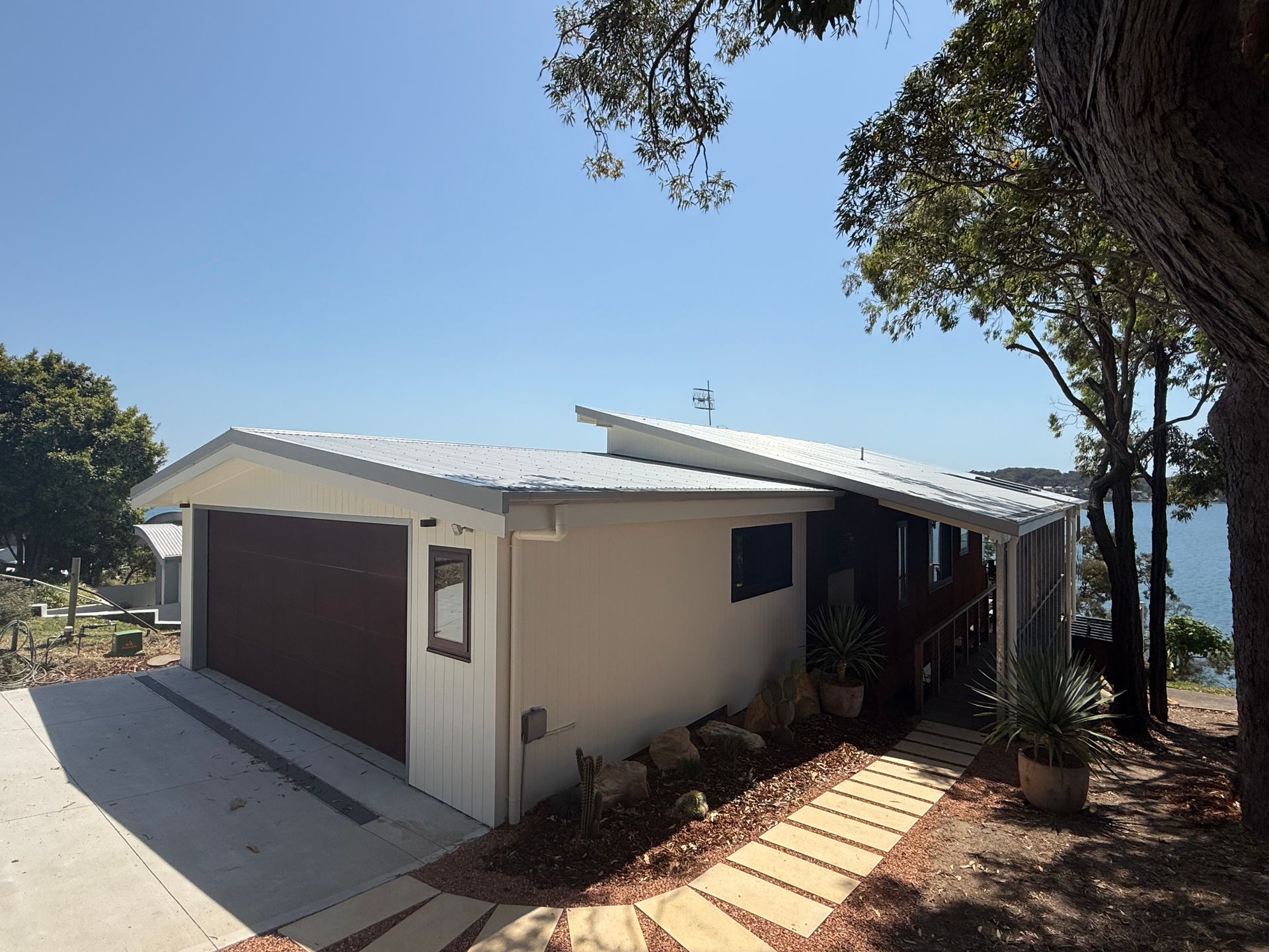 Coastal property under clear blue sky— Hi Tech Roofing in Port Stephens, NSW