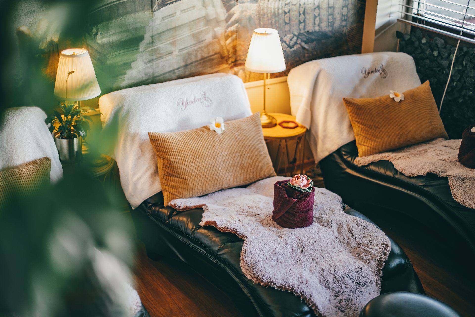 Two spa chairs with pillows, blankets, and small lamps, creating a relaxing ambiance.