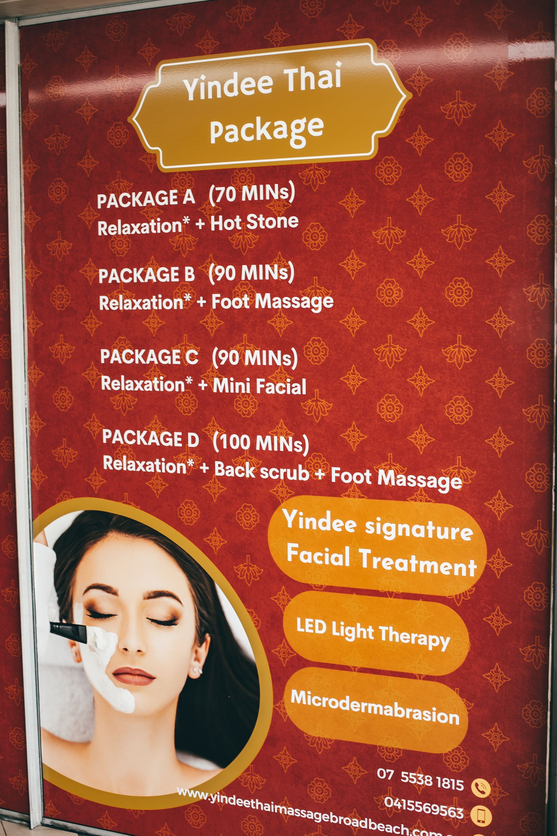 Spa menu poster with Thai packages: relaxation, massages, facial treatments. Woman shown getting facial. Red background.