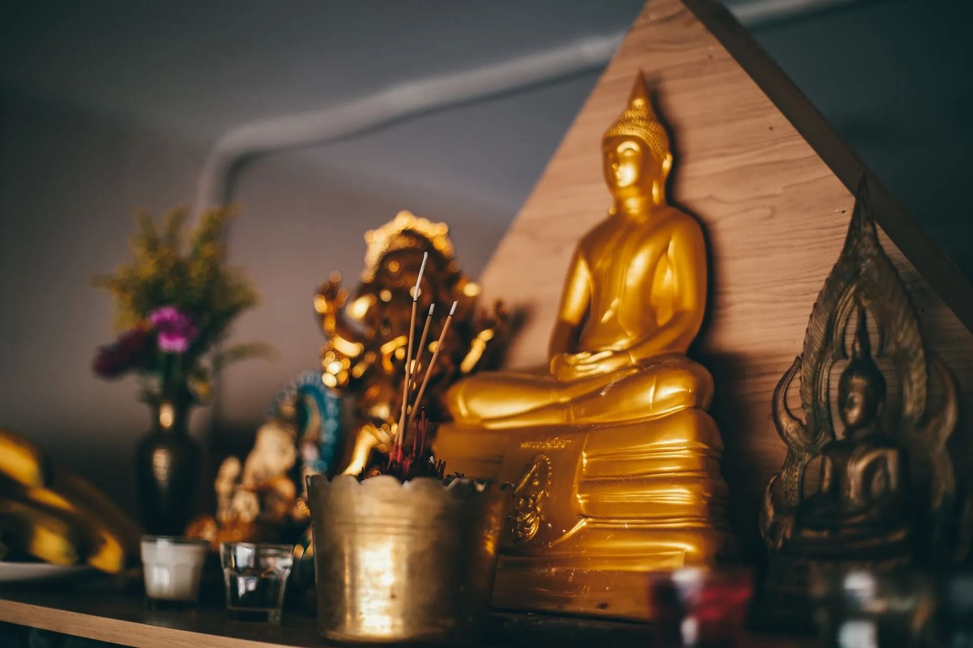 Golden Buddha Statue With Other Religious Figurines on a Shelf — Traditional Massage Services In Broadbeach, QLD