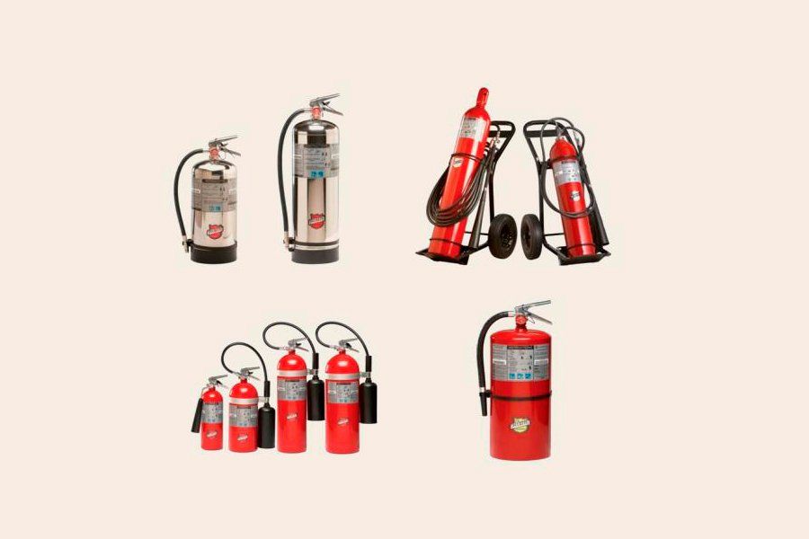 Extintores de incendios de distintos tamaños, plateados y rojos, sobre fondo neutro.