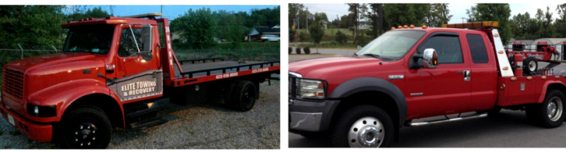 Two red tow trucks side by side, one is a larger model.