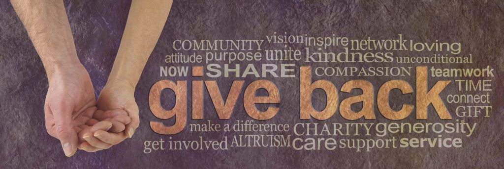 Campaign banner with female hand holding male cupped hand on left and a GIVE BACK word cloud  on right against a rustic parchment background