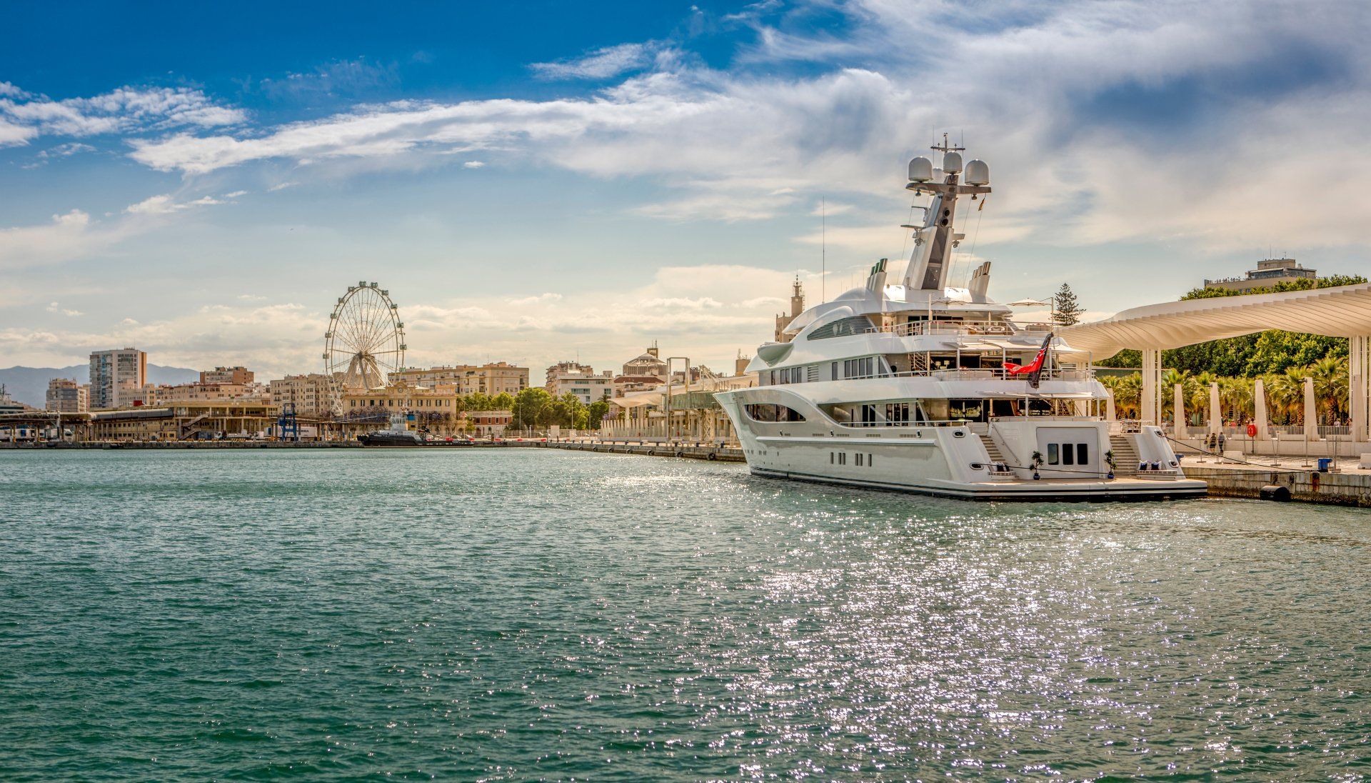 Picture of Marina Malaga, with a big ferris wheel and a superyacht
