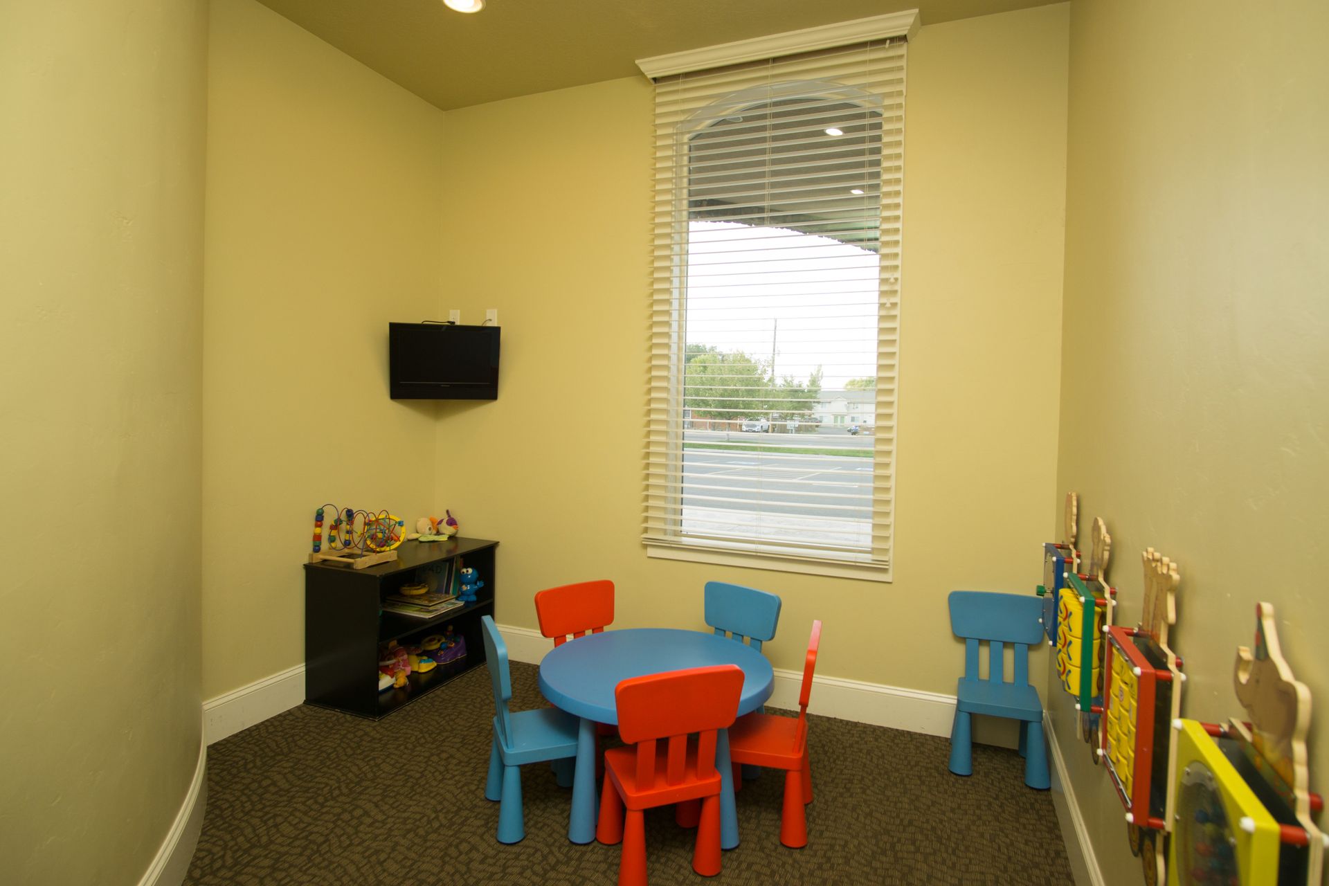 A children 's room with a table and chairs and a television.