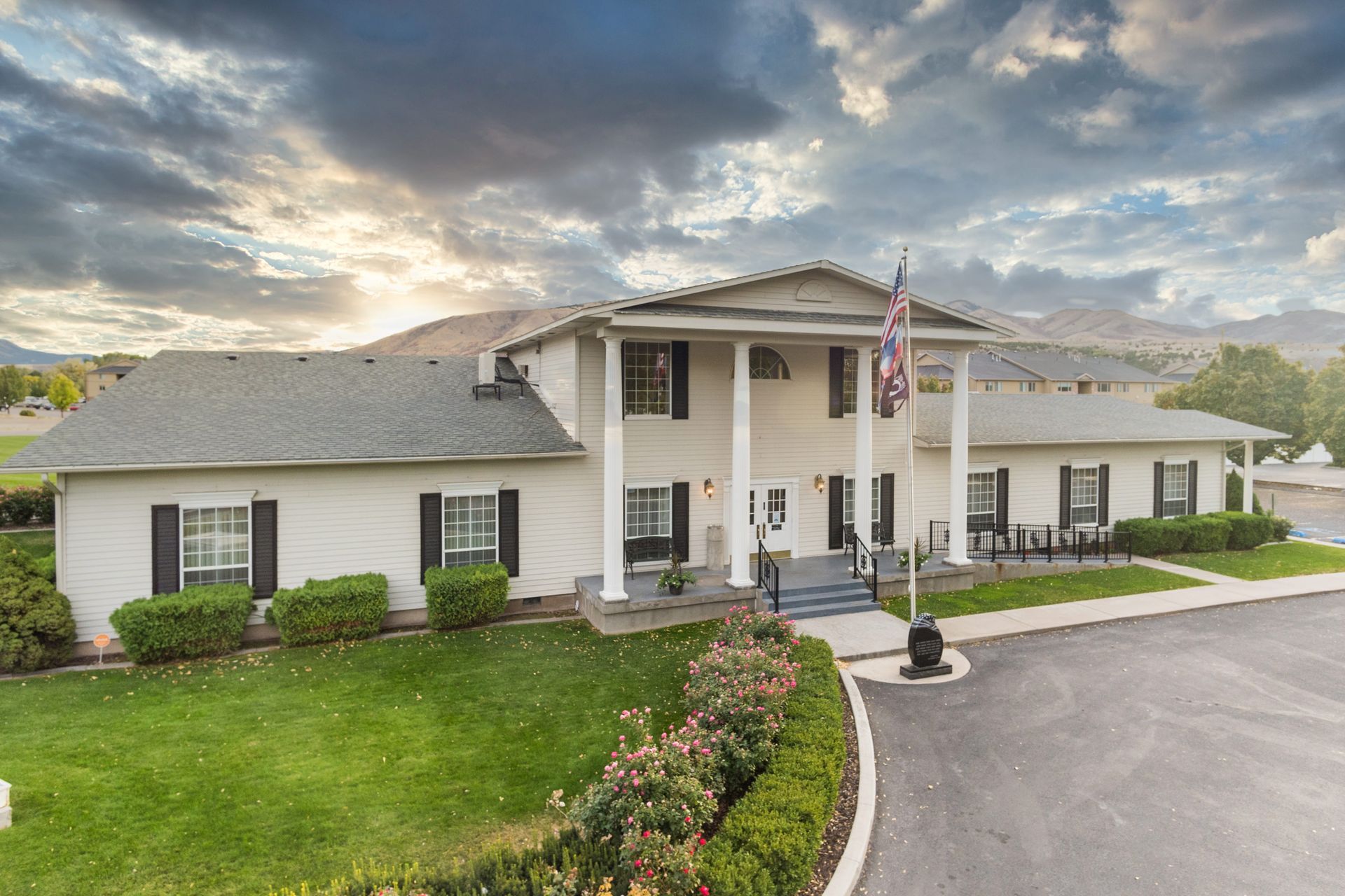 A large white house with a flag in front of it.