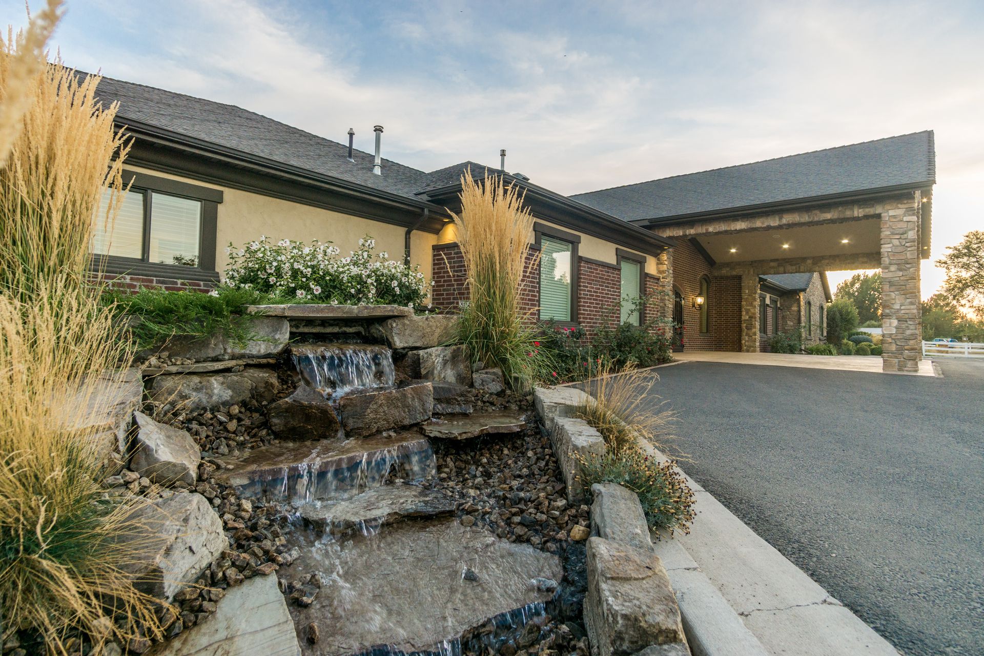 A large house with a waterfall in front of it.