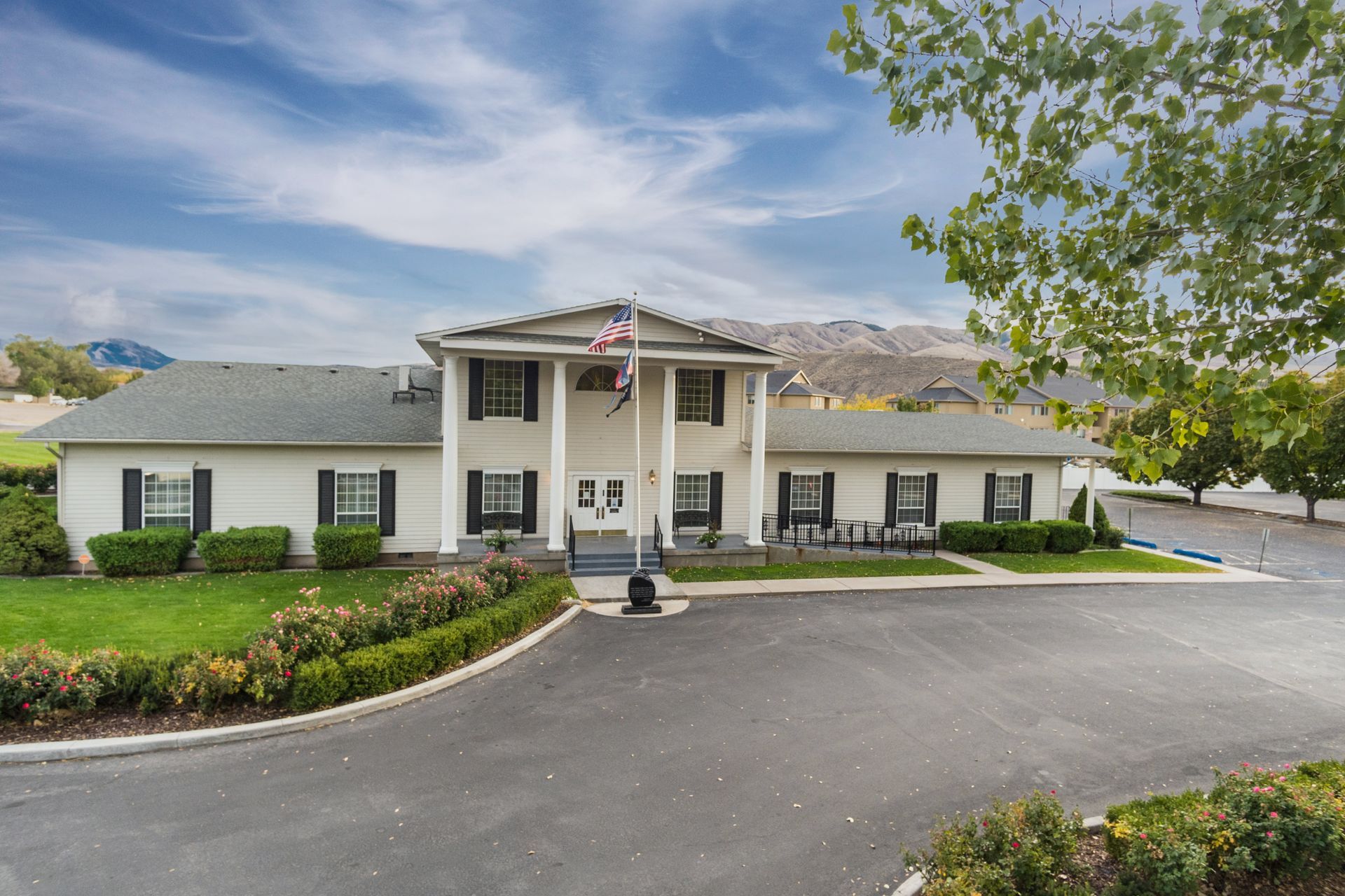 A large white house with a flag on top of it