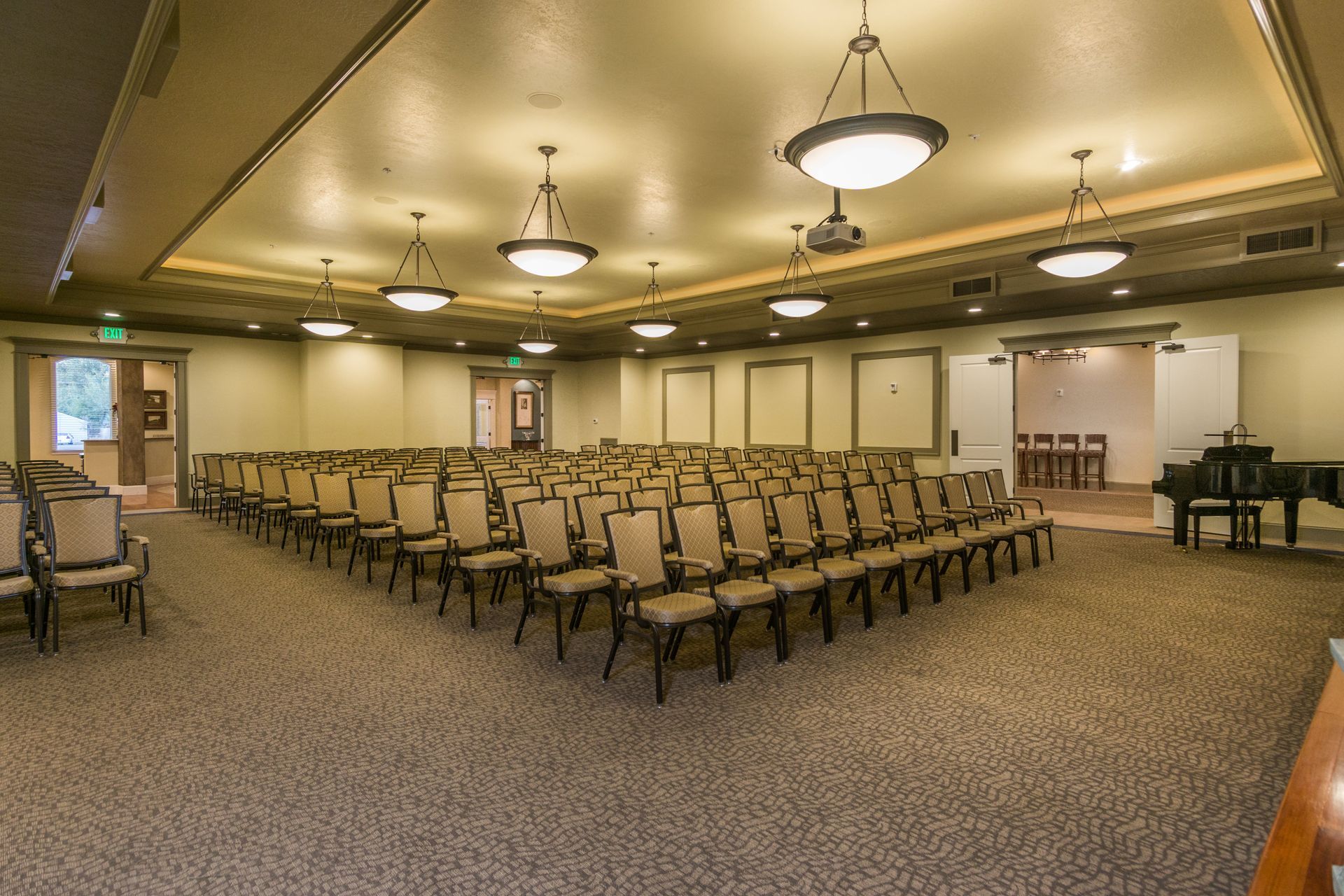 A large room with rows of chairs and a piano.