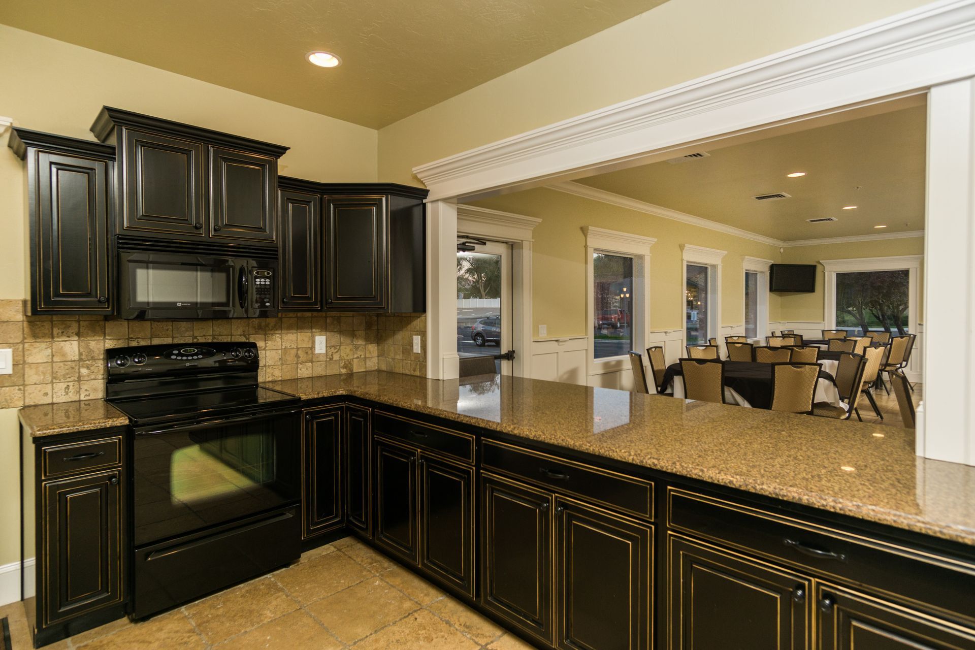 A kitchen with black cabinets and granite counter tops.