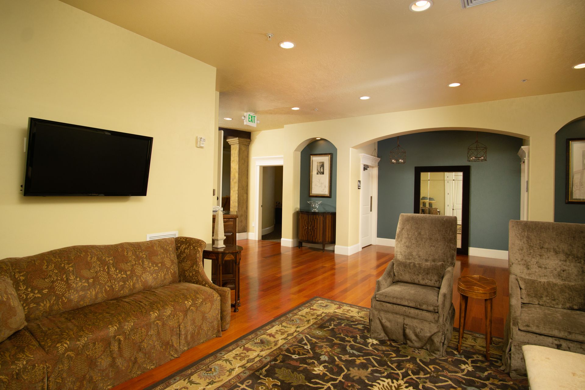 A living room with a couch , chairs and a flat screen tv.