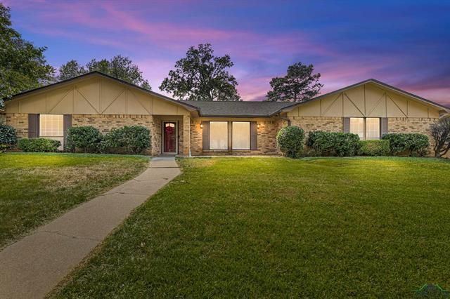 A living room with a couch , chairs , ottoman and a mirror