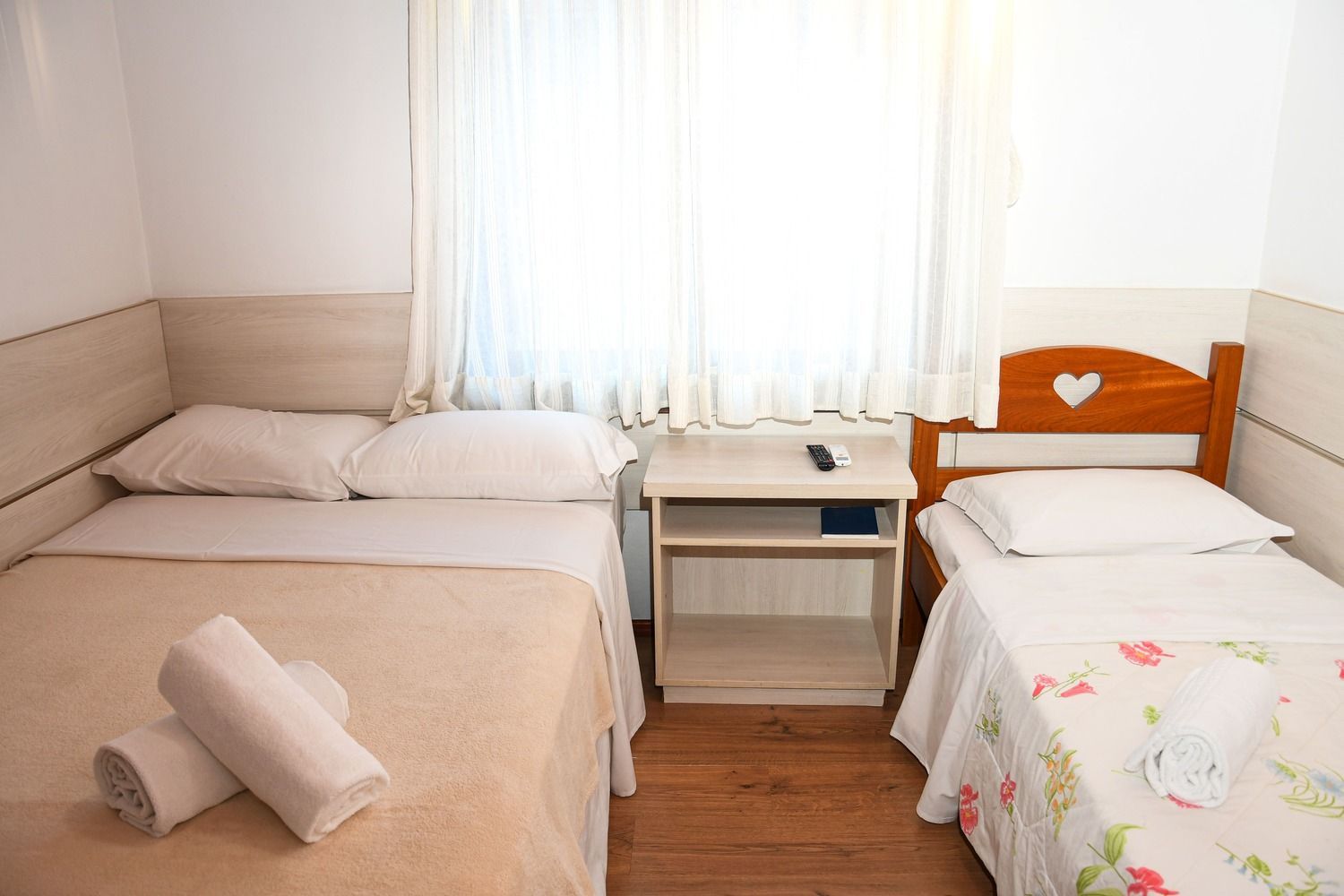 Um quarto de hotel com duas camas e uma mesa de cabeceira.