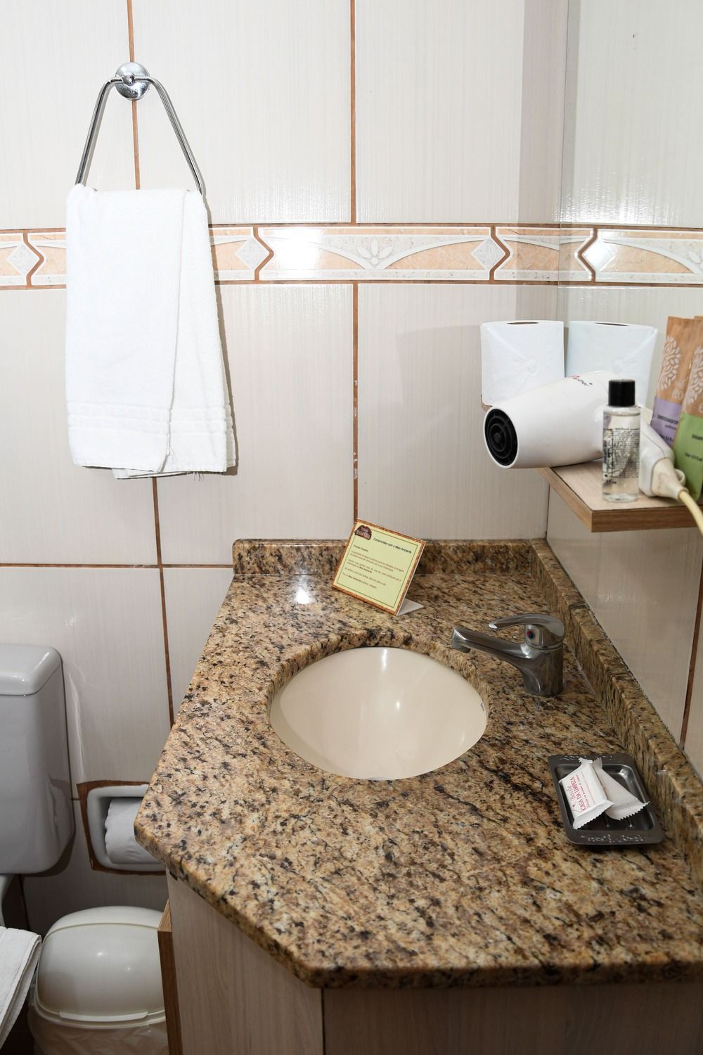 Um banheiro com pia, vaso sanitário e espelho.