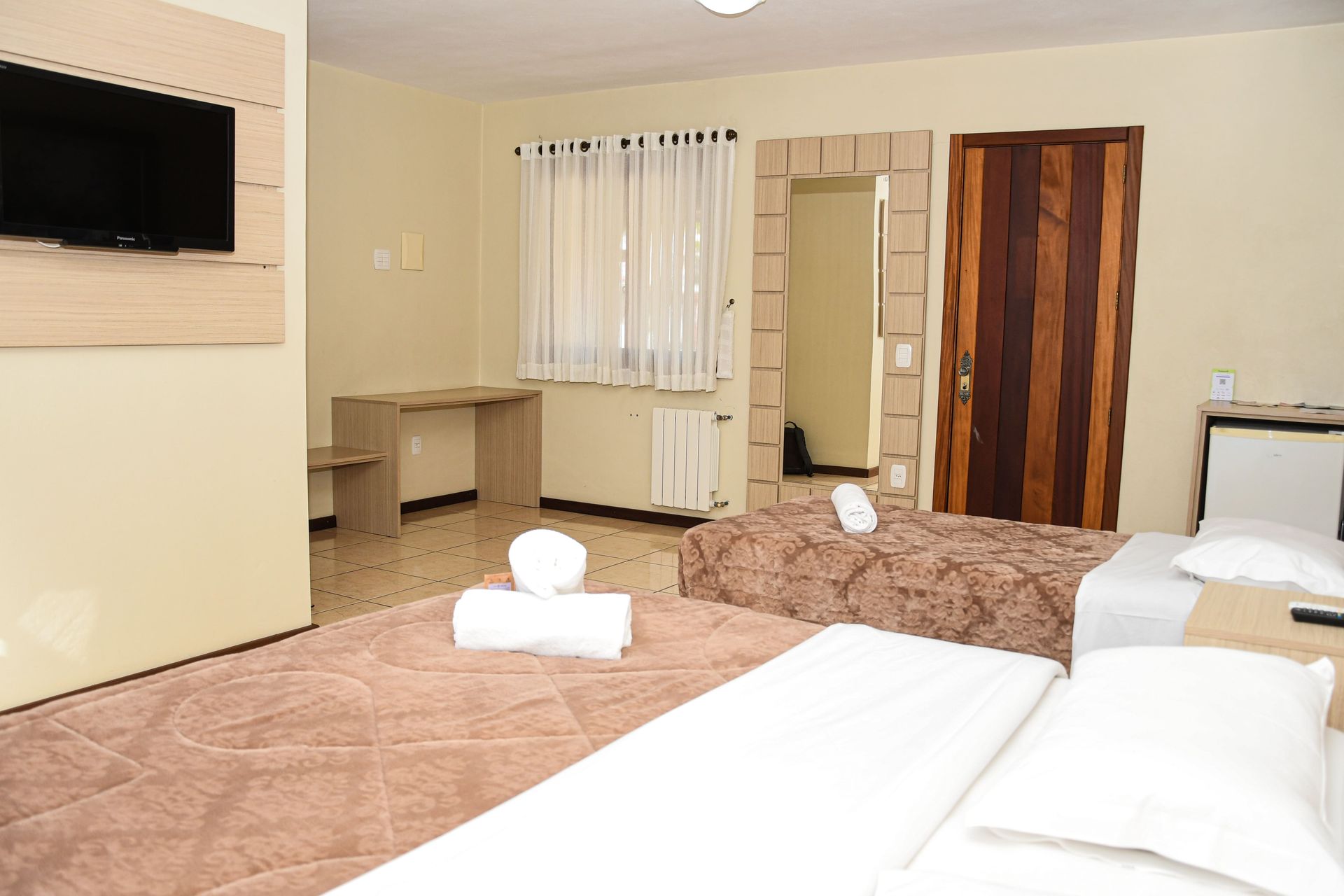 Um quarto de hotel com duas camas e uma TV de tela plana