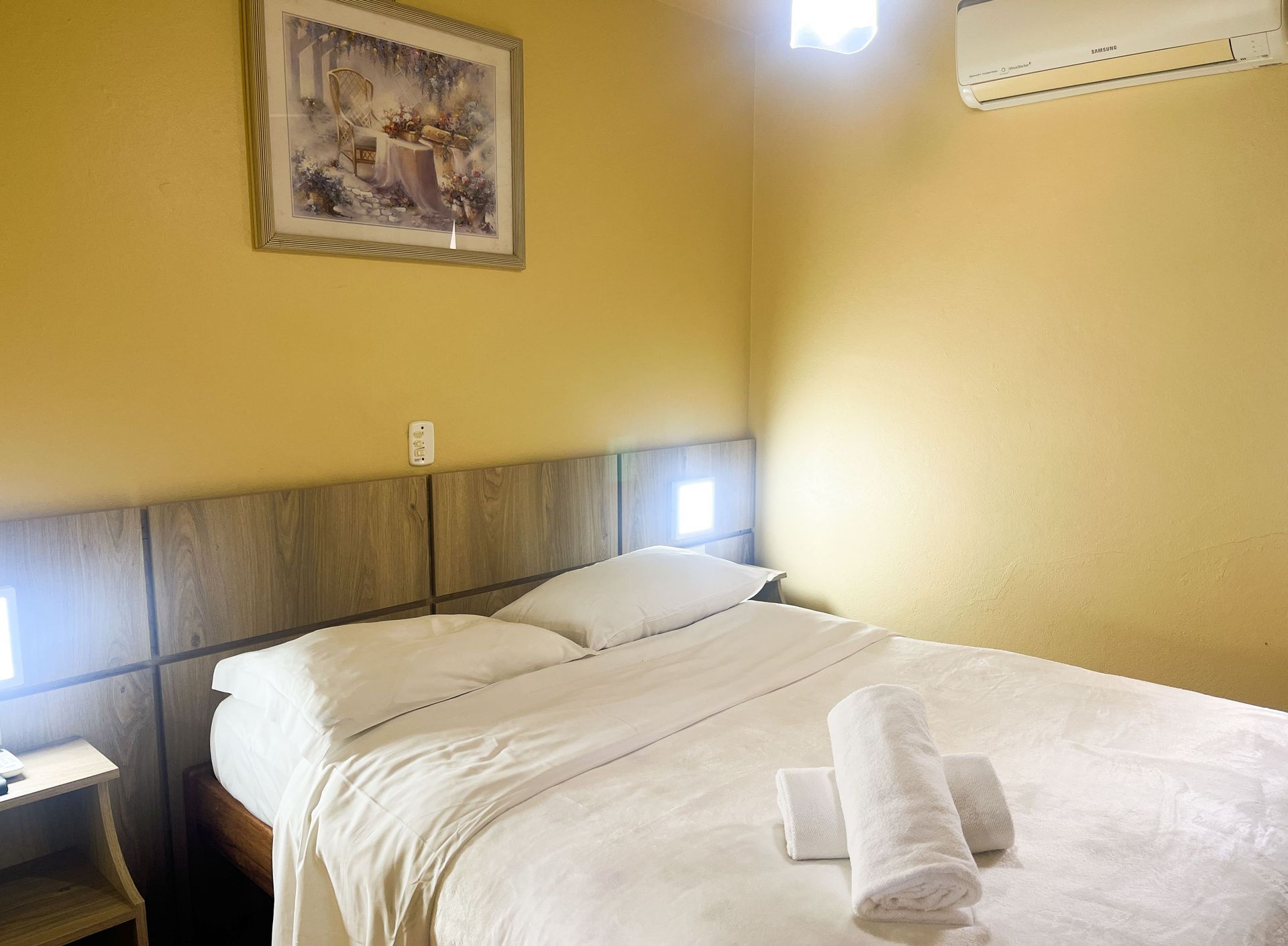 Há uma foto na parede acima da cama no quarto.