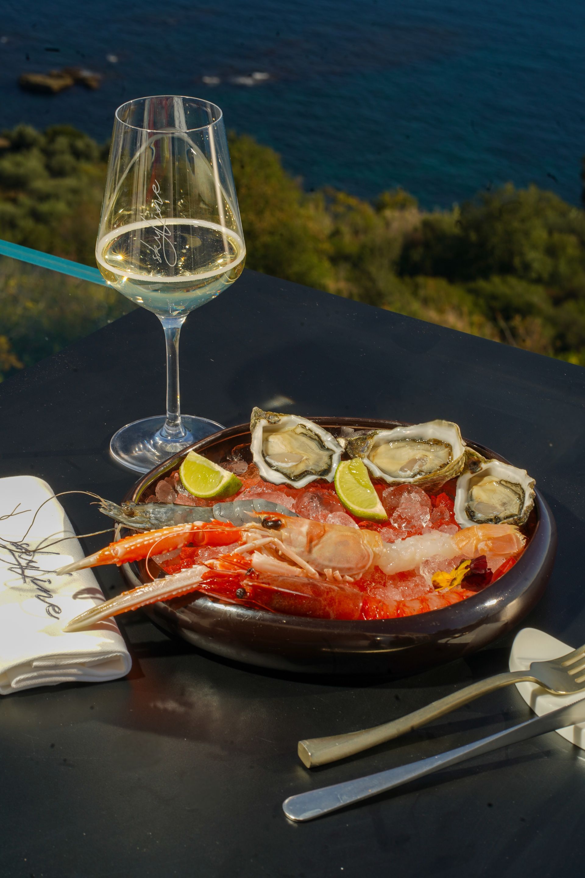 Piatto di cibo gourmet con vino bianco e un tovagliolo su una superficie nera.