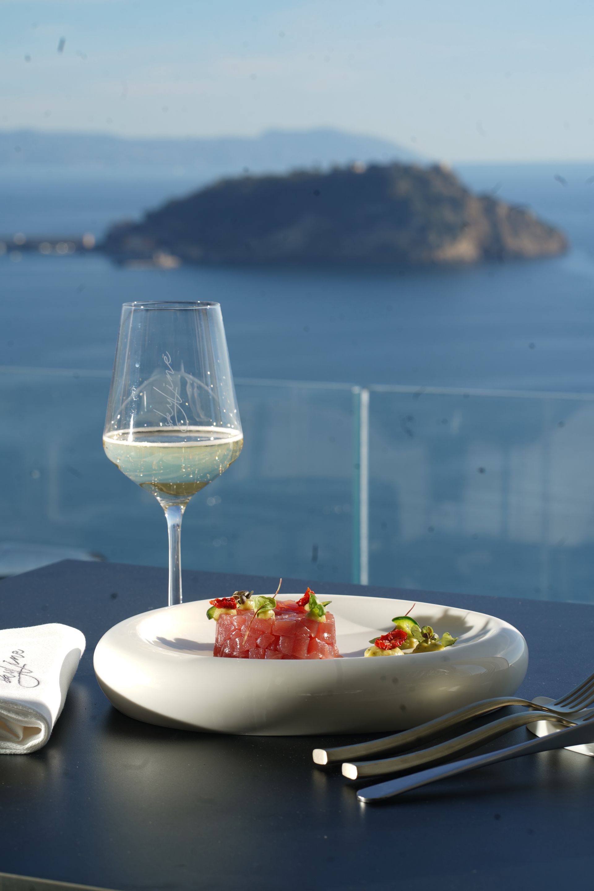 Piatto con frutti di mare crudi, salse gialle e rosse e un tovagliolo con la scritta 