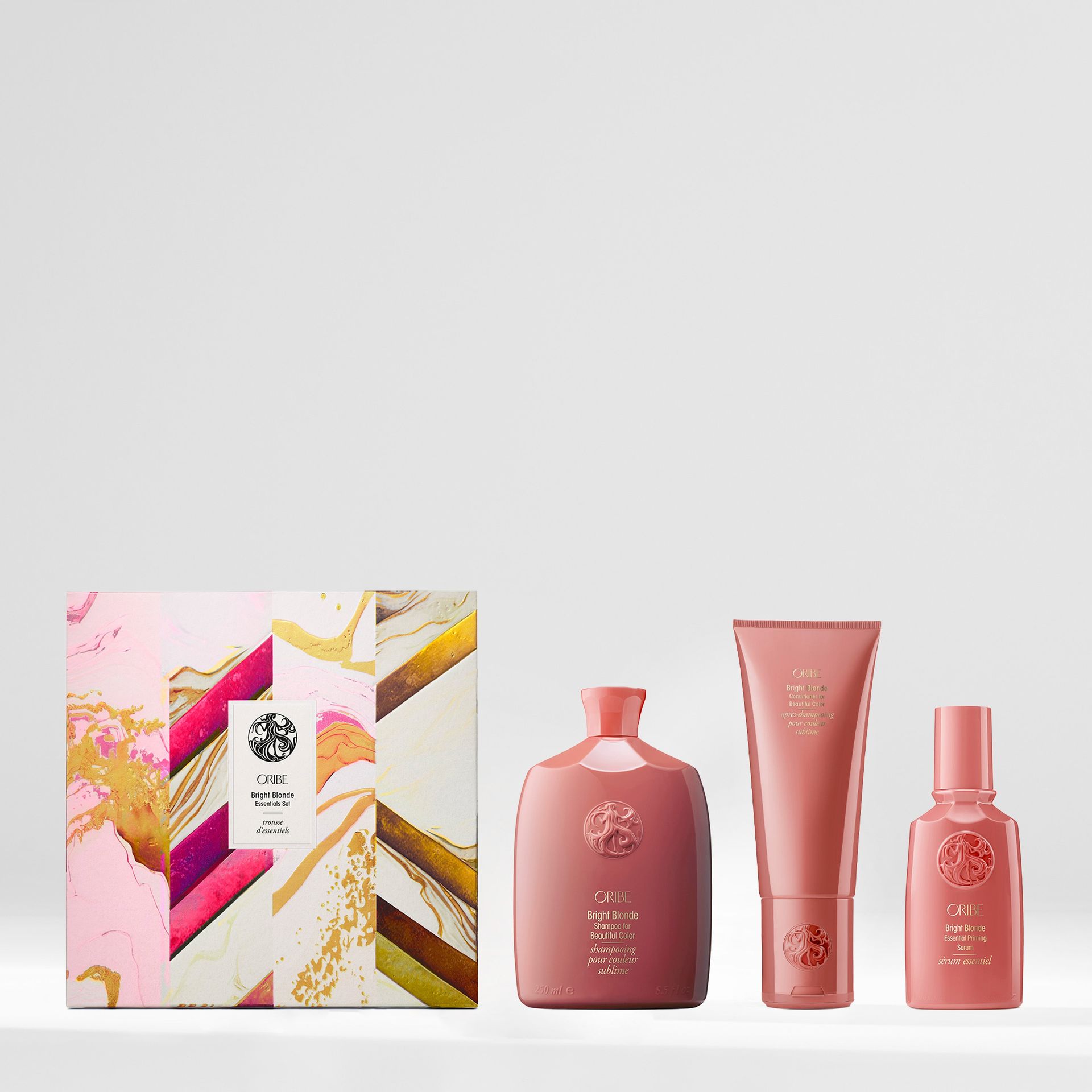 A luxury hair care gift set featuring a decorative box, a shampoo bottle, a conditioner tube, and a styling product.