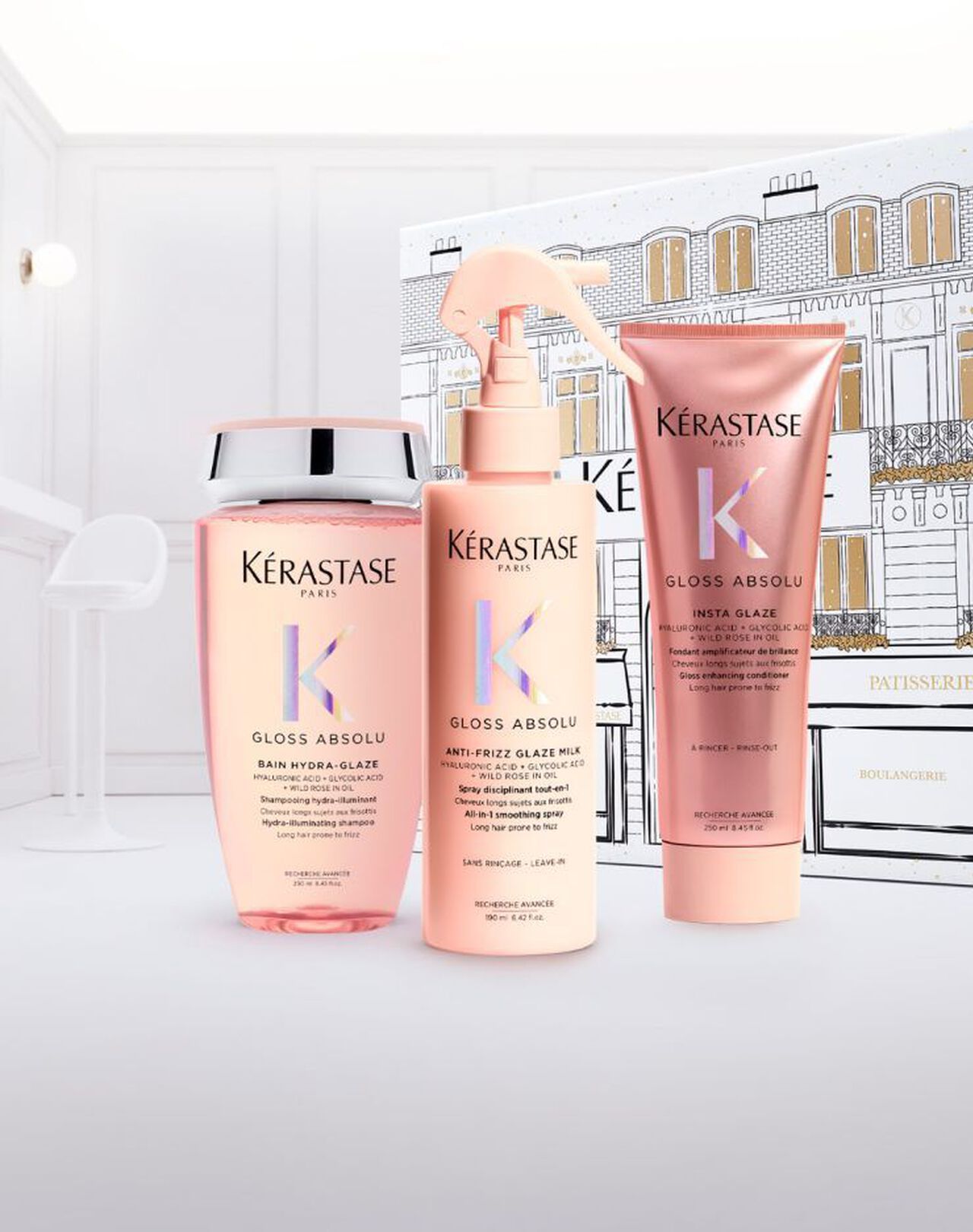 Three Kérastase Blond Absolu hair care products in pink bottles, including shampoo, a spray, and a tube, on a white surface.