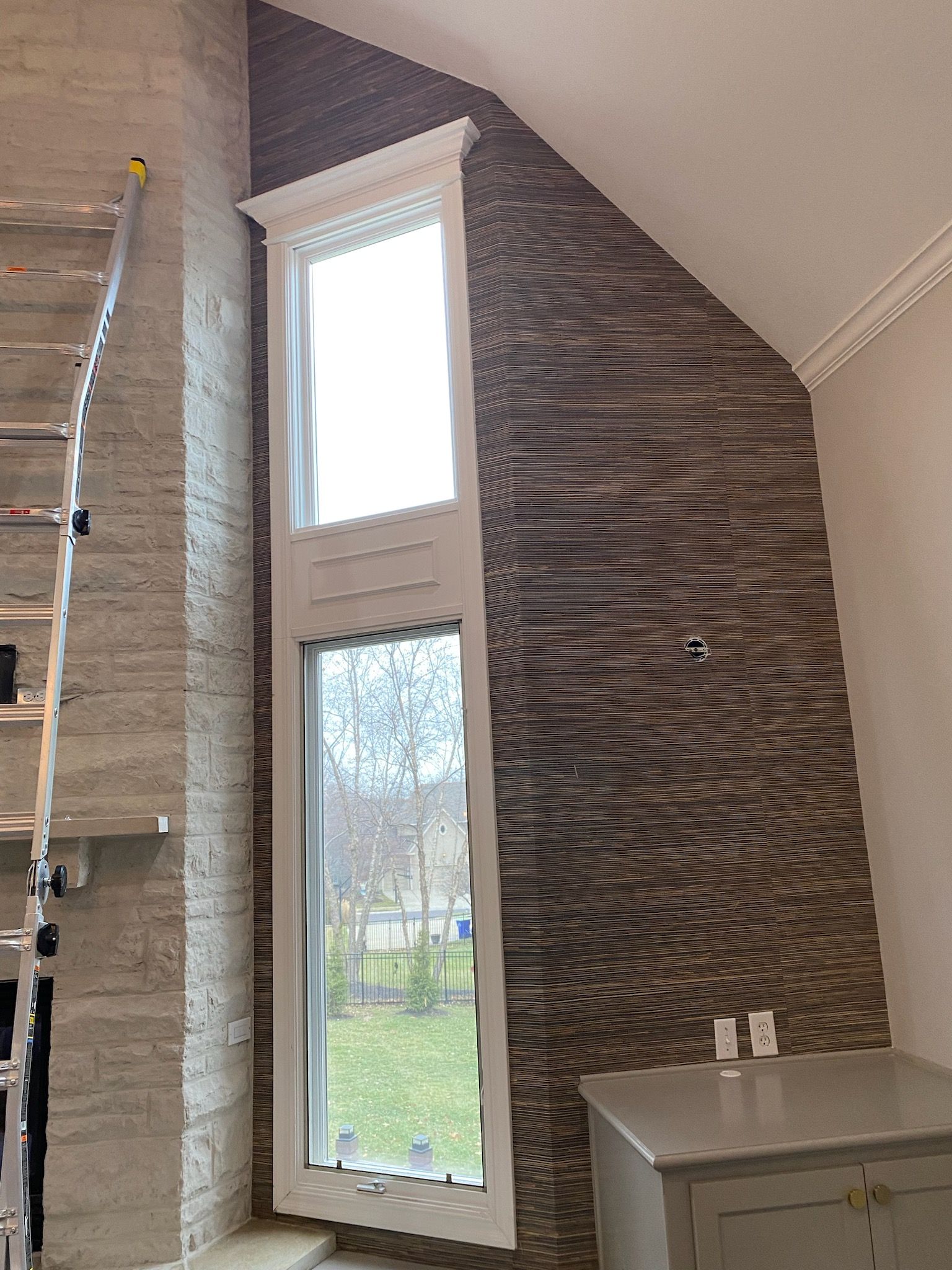 A bathroom with a large window and a ladder.