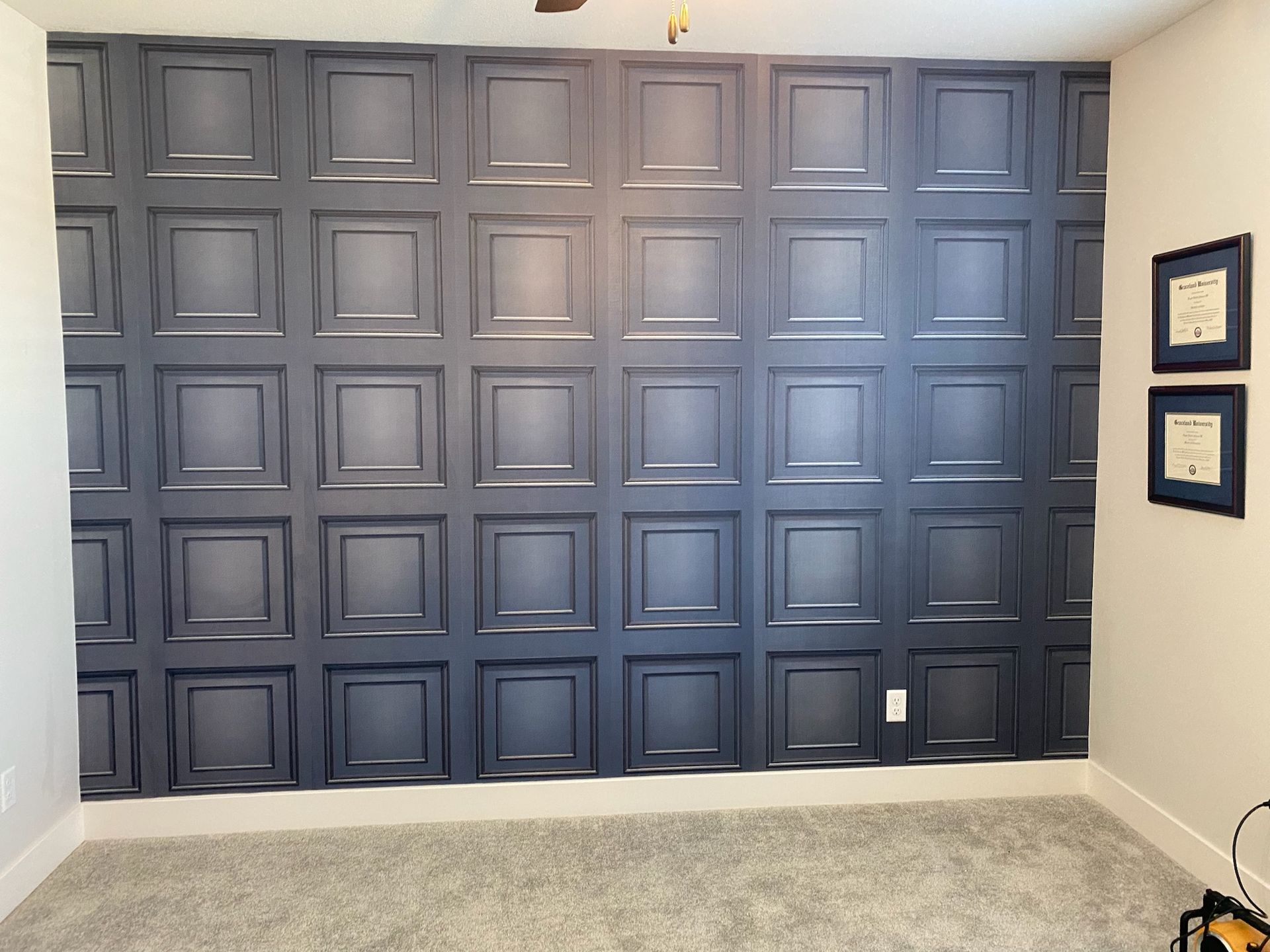 A room with a black wall with squares on it