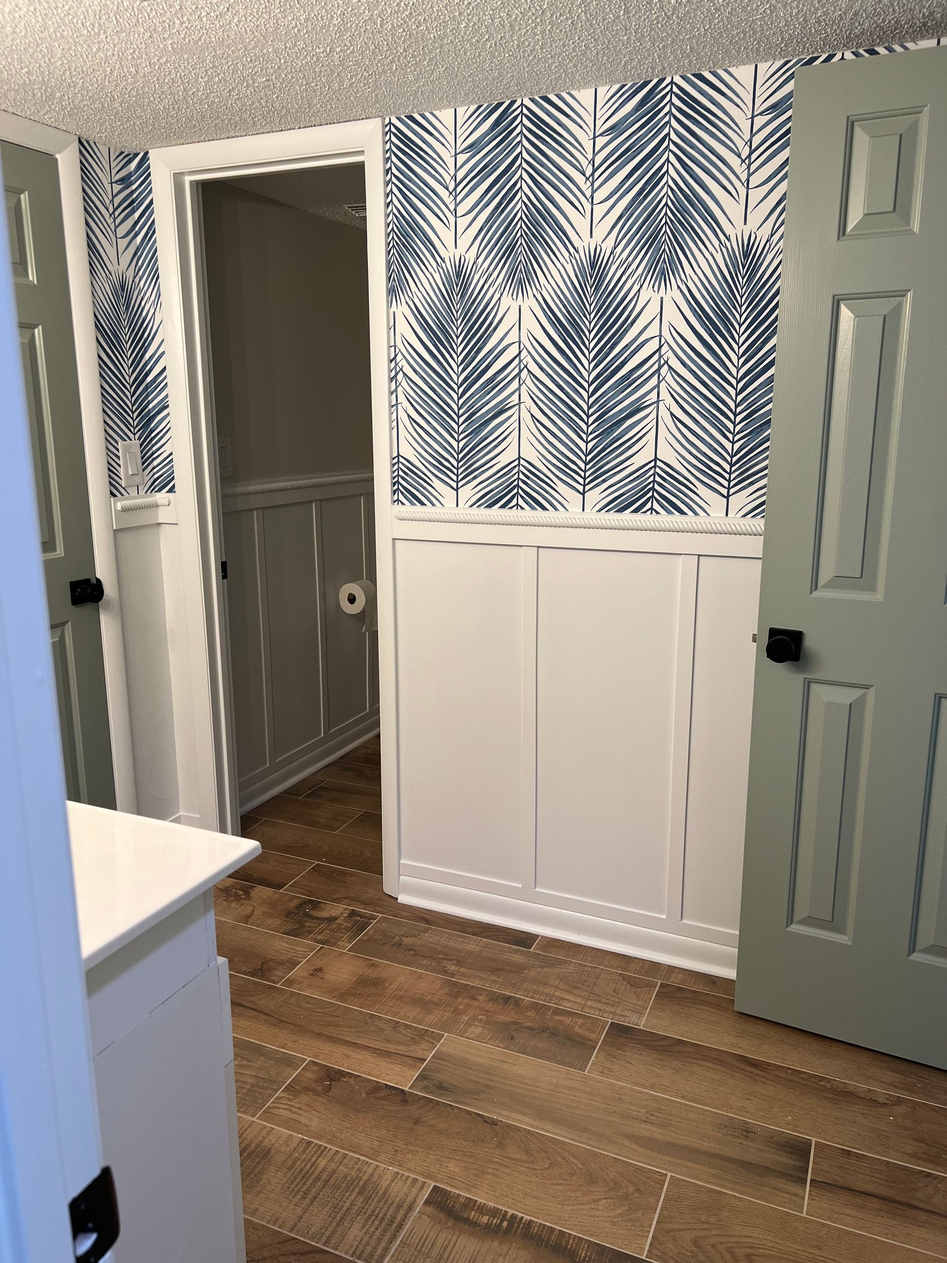 A room with a blue and white wallpaper on the wall.