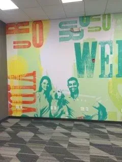 A wall with a picture of a man and woman and the words welcome