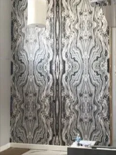 A living room with a black and white wallpaper on the wall.