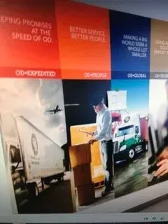 A man is standing in front of a truck with boxes on it.