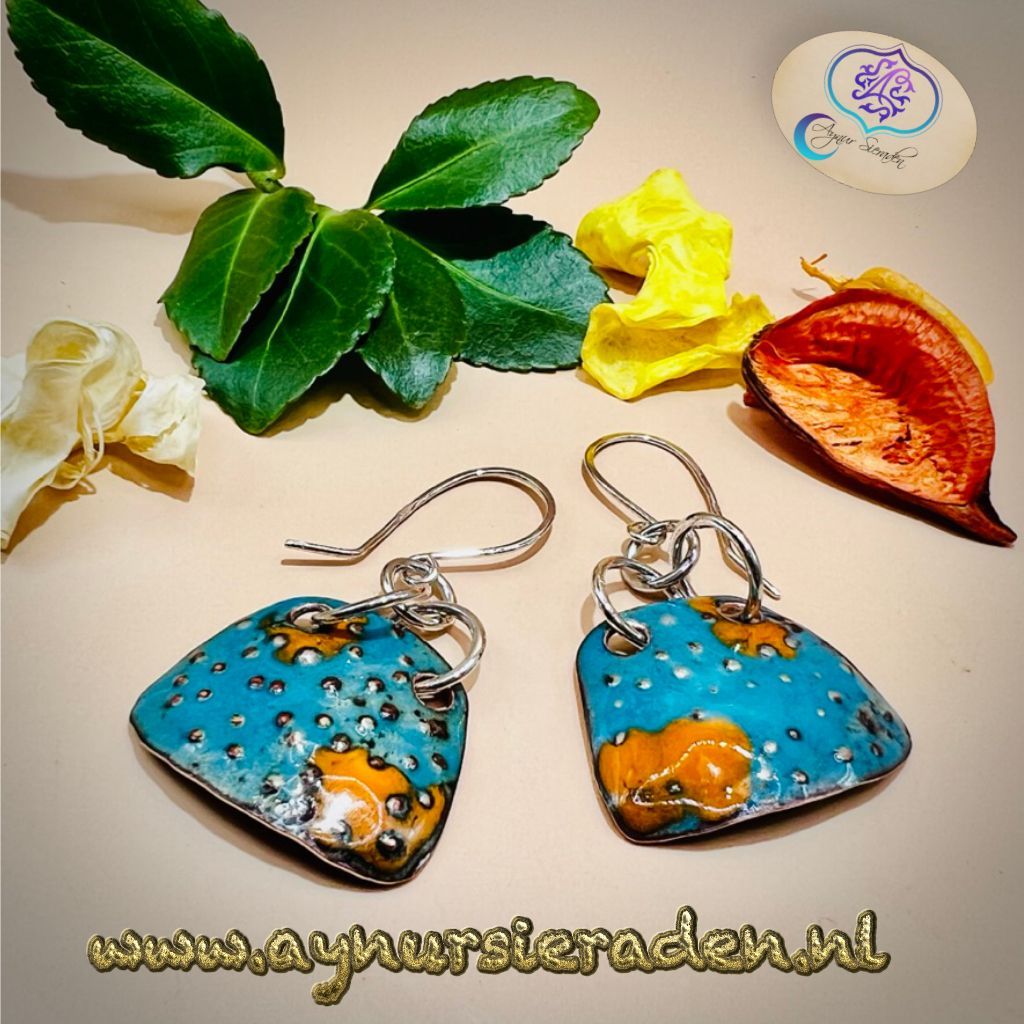 Aynur Sieraden, Uniek, bijzonder & 100% handgemaakt. Deze oorbel is versierd met prachtig blauw en oranje emaille. De basis van het emaille is van koper, het oorhaakjes en de onderdelen zijn gemaakt van 925 sterling zilver.