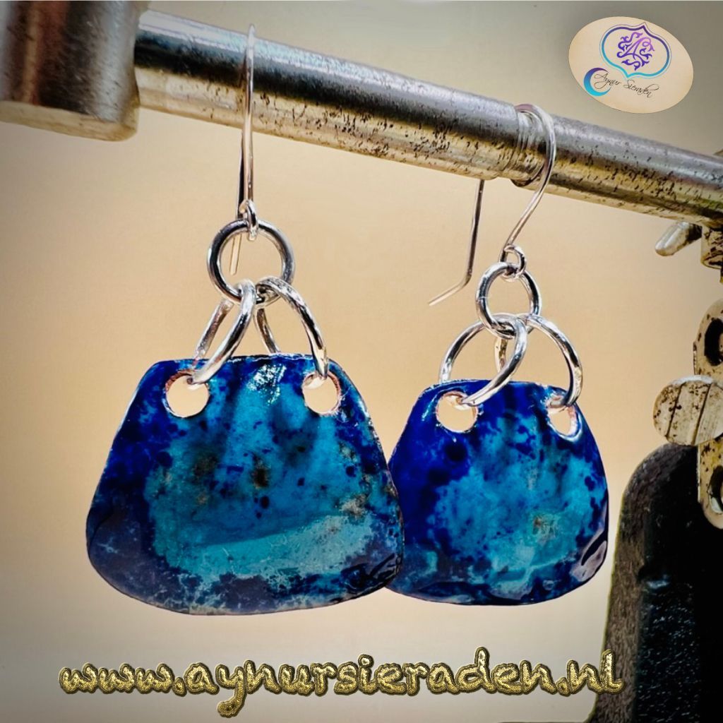 Aynur Sieraden, Uniek, bijzonder & 100% handgemaakt. Er zijn 4 versies van deze oorbellen, deze variant is een van mijn favorieten. De eenvoud geeft het zijn schoonheid, het heeft prachtige kleuren, dit geeft het sieraad zijn karakter. De kleur doet me denken aan de diepblauwe oceaan. Het is geweldig. Deze oorbel is versierd met prachtig blauw emaille. De basis van het emaille is van koper, het oorhaakjes en de onderdelen zijn gemaakt van 925 sterling zilver.
