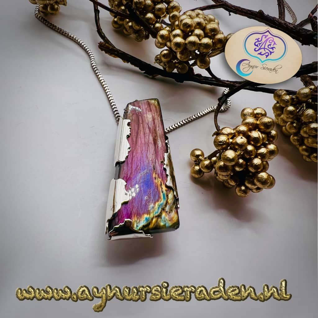 Aynur Sieraden, Paars Rivier, Zilveren hanger met een paarse labradoriet van de Aynur Sieraden. De lange vorm van labradoriet en het zilver eromheen doen denken aan een prachtige paarse rivier.