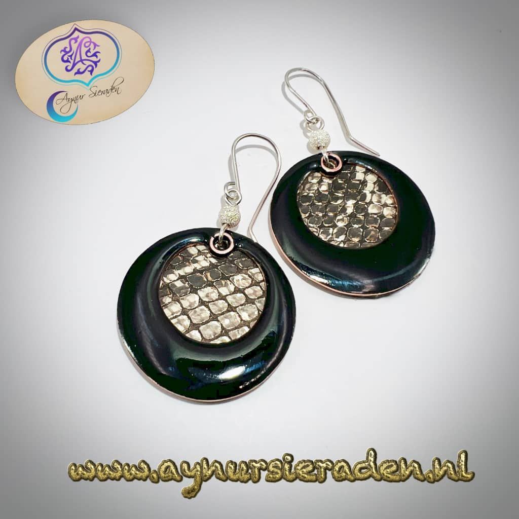 Aynur Sieraden, Deze oorbel wordt op bestelling gemaakt. De hanger is zilver. De oorbellen zijn versierd met email en leer. Het slangenpatroon van het leer wordt bijzonder gemaakt door een speciale zilverachtige glans.