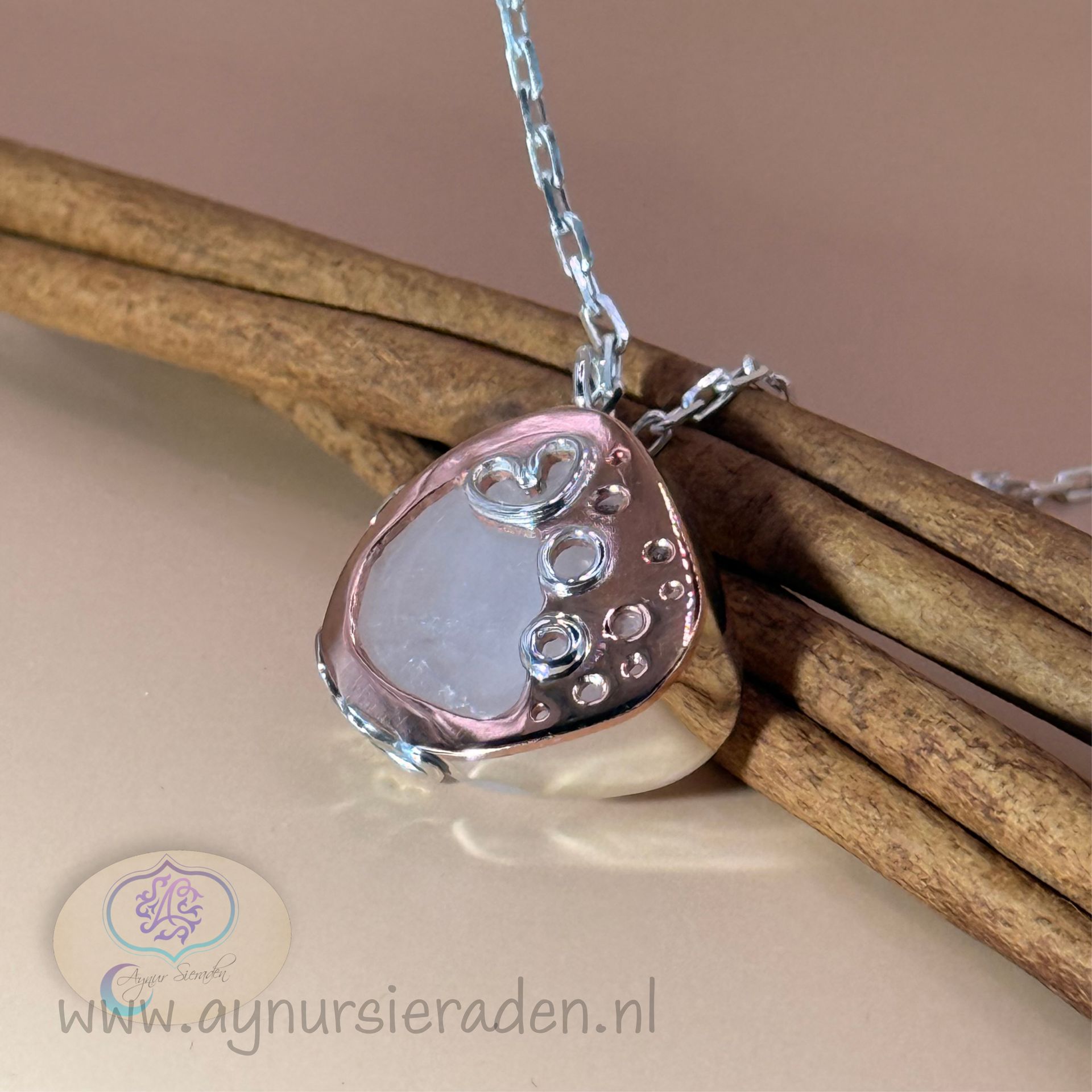 Achterzijde van handgemaakte zilveren hanger met rozenkwarts en koperen details – Aynur Sieraden