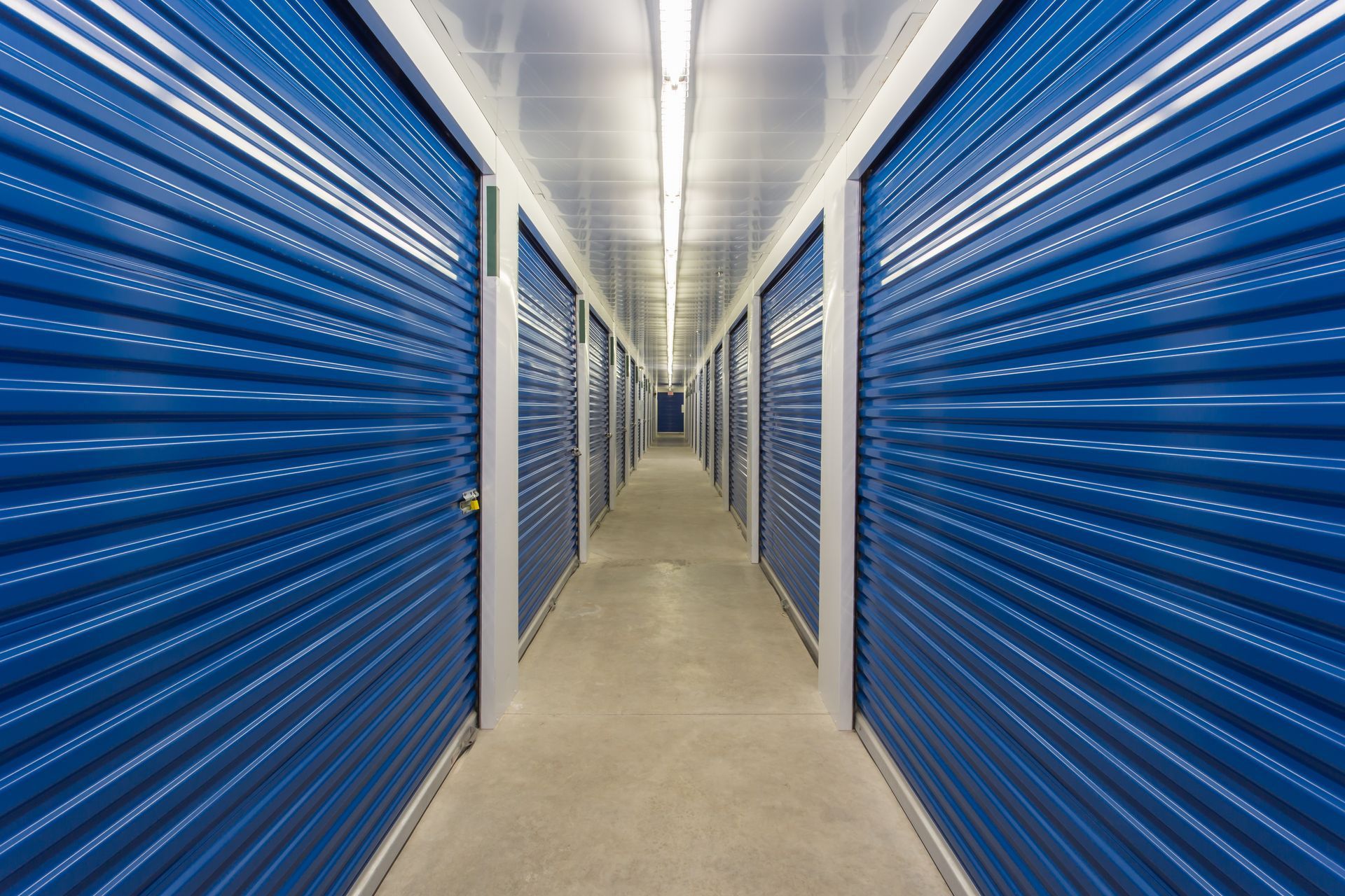 The interior of a self-storage facility showing the individual storage unit metal roll up doors