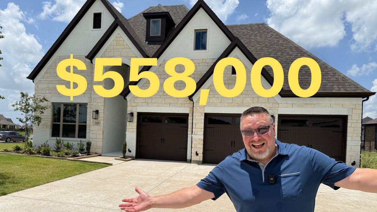 A man is standing in front of a house that is worth $ 558,000.