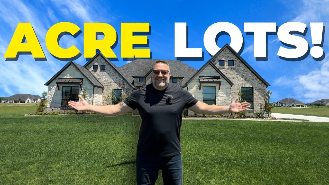 A man is standing in front of a house that says acre lots.