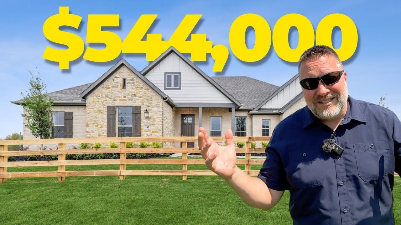 A man is standing in front of a house that is for sale for $ 540,000.