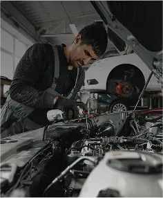 Technician examining engine of vehicle | Foltz Automotive