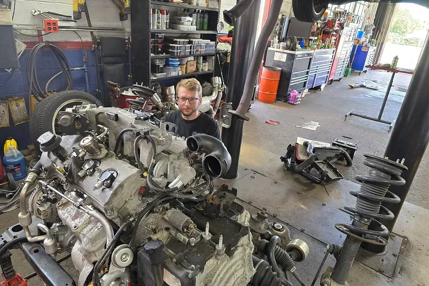 Technician working on back of vehicle | Foltz Automotive