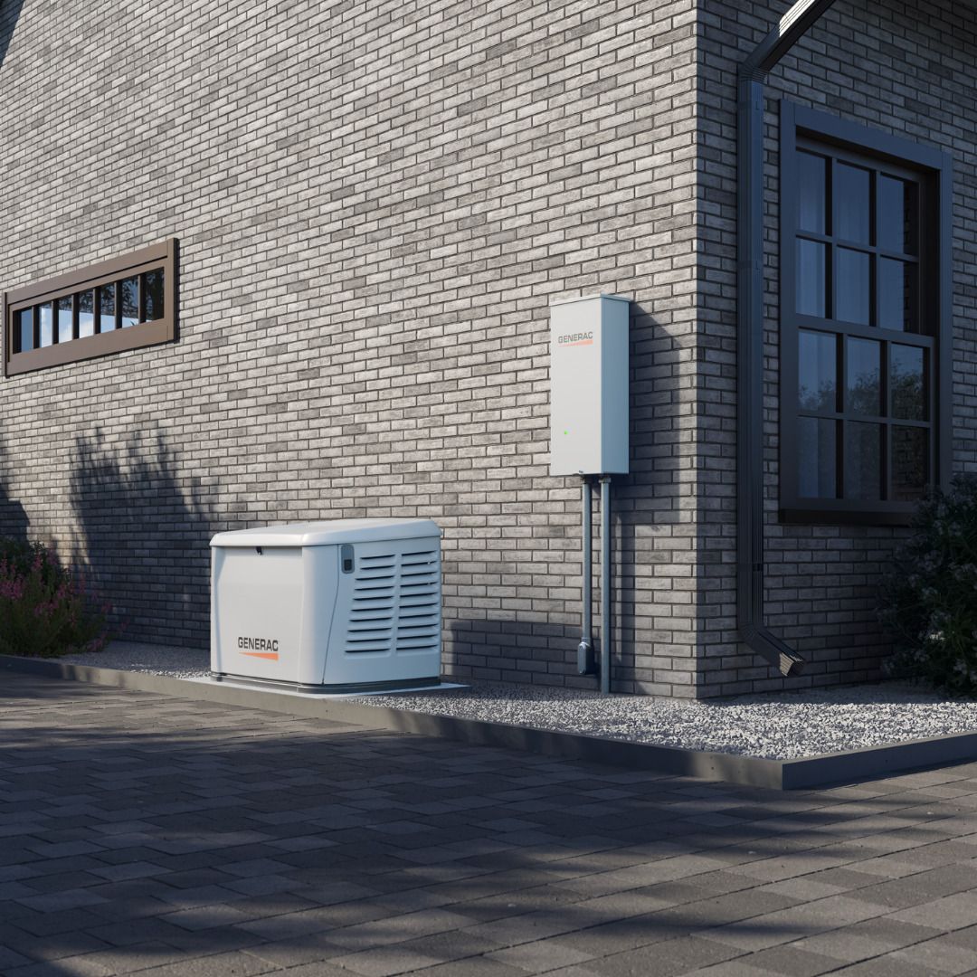 A white Generac standby generator and matching transfer switch mounted on a gray brick exterior wall of a home.